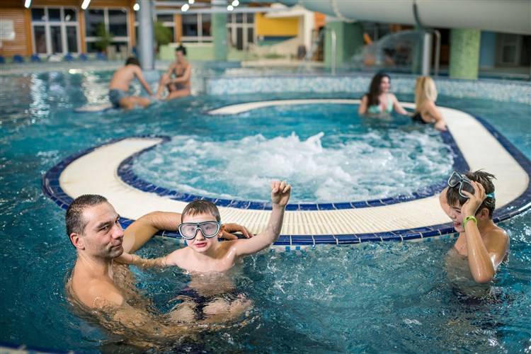 Pohled na rodinu hrající si ve vnitřním aquaparku hotelu Frymburk. | FRYMBURK - Frymburk