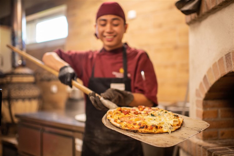 Kuchař vytahující pizzu z pece. | FRYMBURK - Frymburk