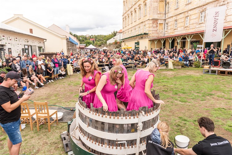 Pohled na ženy šlapající víno v sudu. | BURČÁKFEST ZNOJMO 2025 - Hotel MARIEL