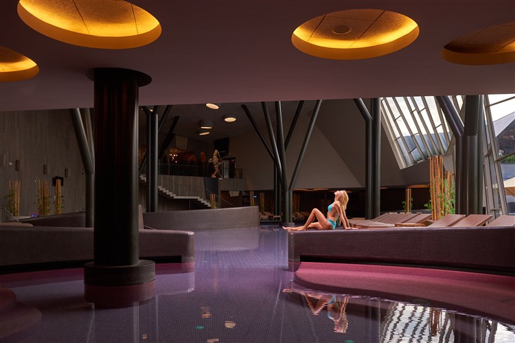 Pohled na ženu odpočívající na zídce bazénu v klidové zoně SPA. | BREZA**** - Terme Olimia